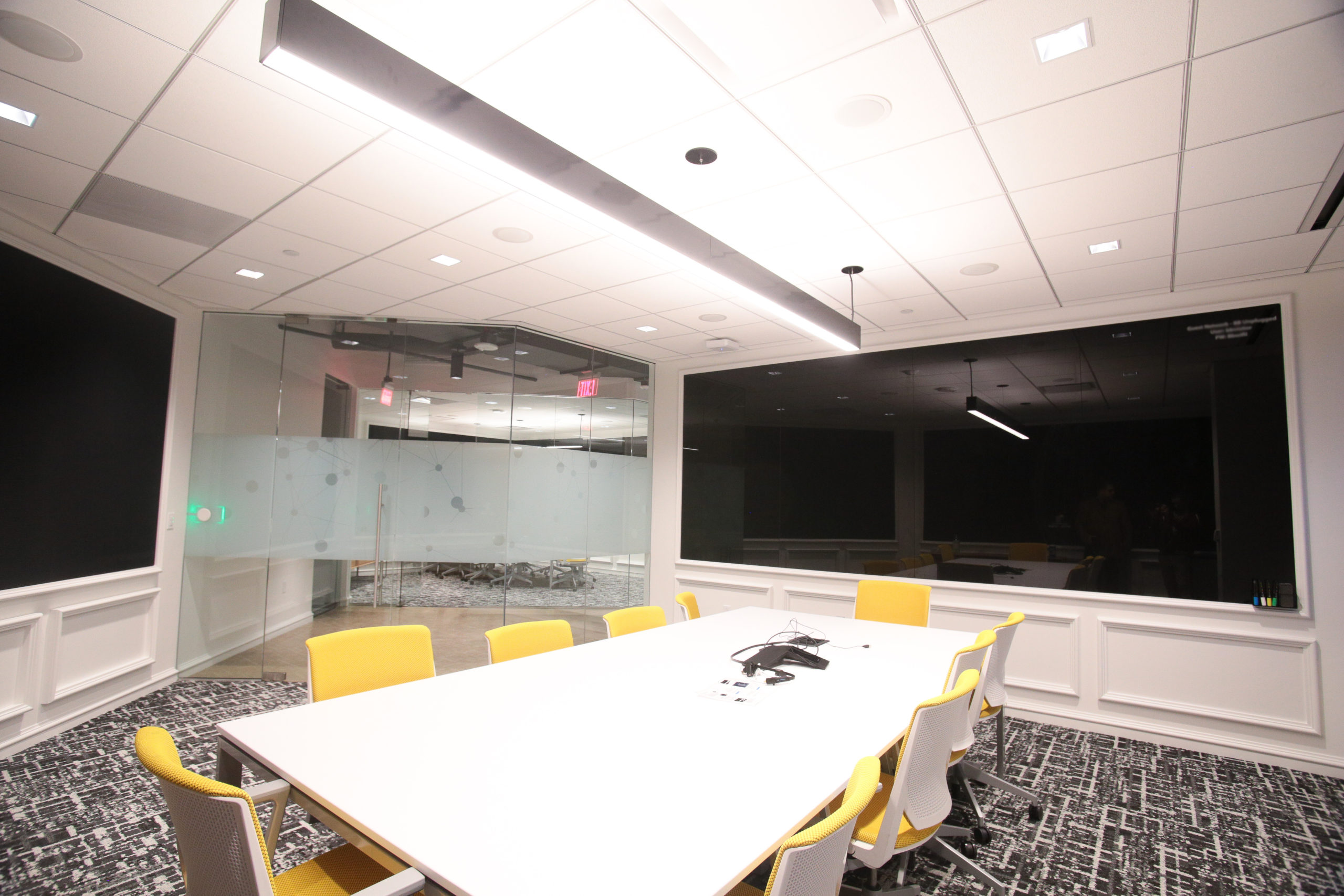 Conference room with glass walls and a back painted glass marker board.